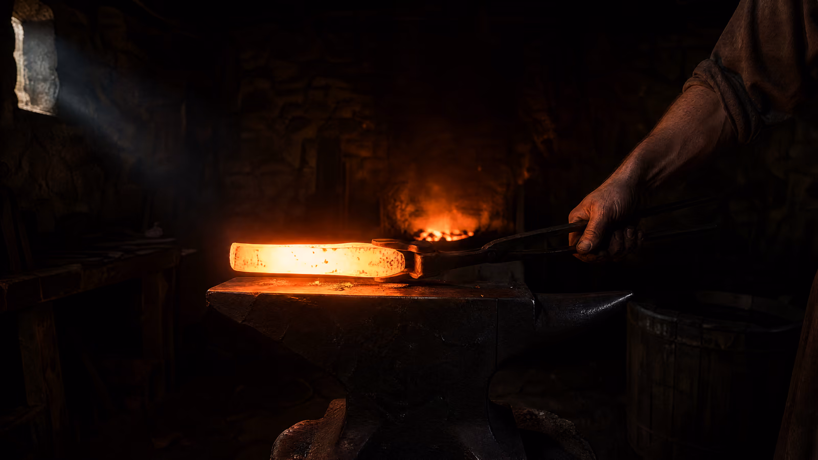 A billet of steel at white heat held in tongs over the anvil.